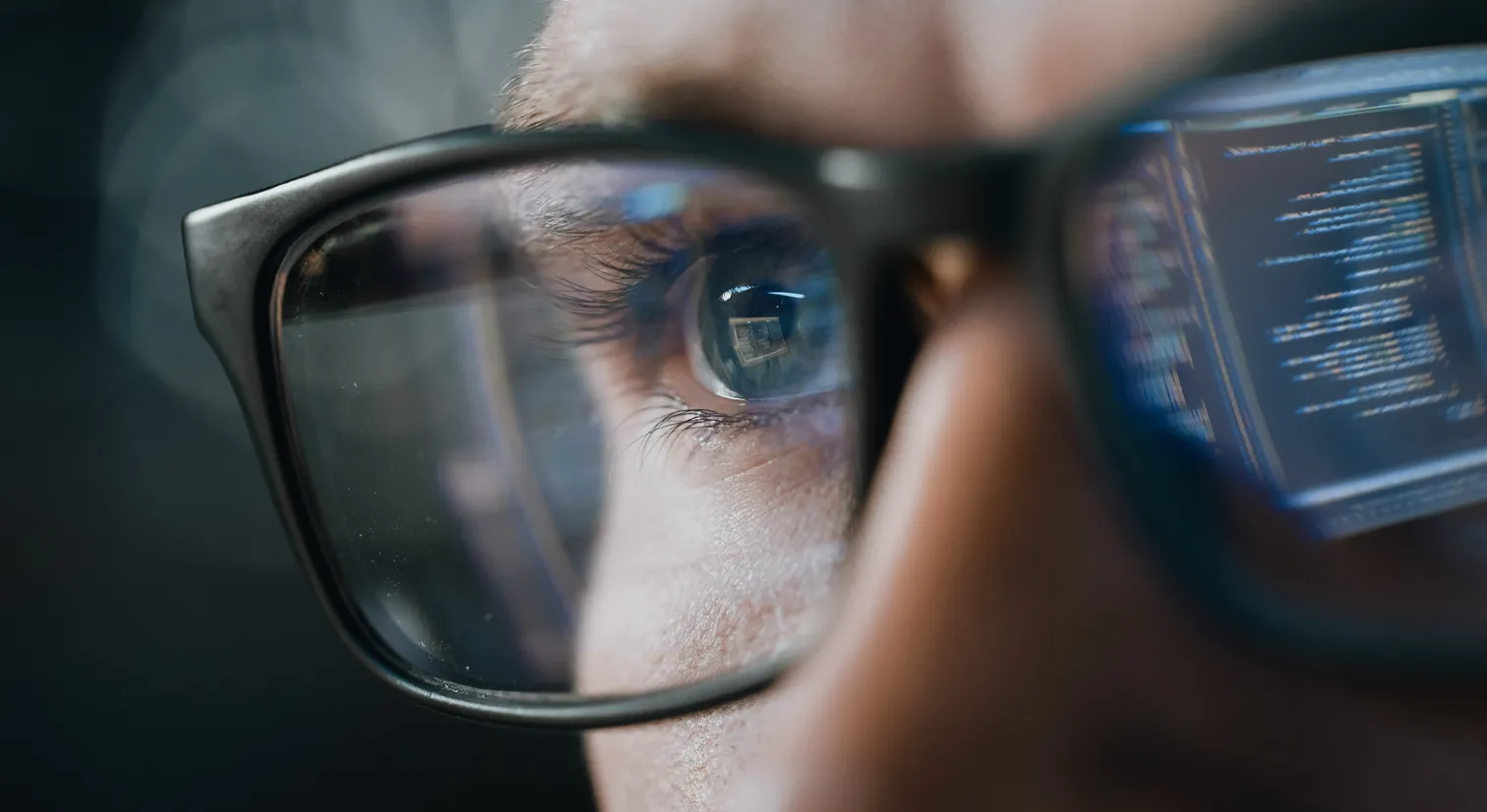 Mann mit Brille, wo ein Brillenglas Programmiercode zeigt
